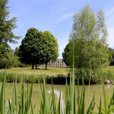 Vue sur le plan d'eau au premier plan et le chateau au fond