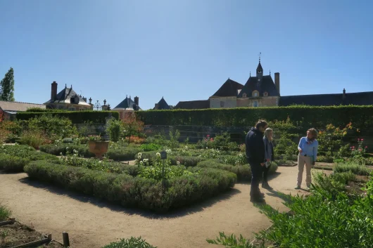 Couple de visiteurs se promenant dans les jardins avec une guide