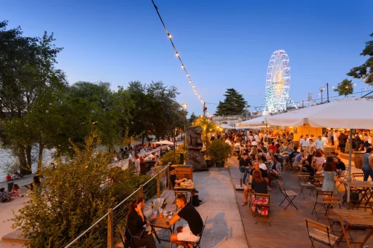 La guinguette de Tours le soir, les gens en terrasse, on voit la grande roue