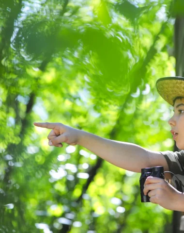 Enfant observant la nature, des jumelles à la main