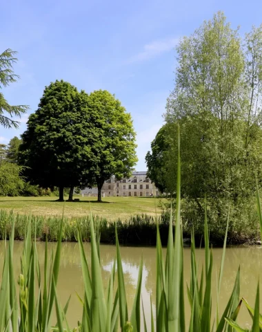 Vue sur le plan d'eau au premier plan et le chateau au fond