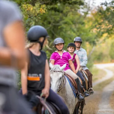 Groupe enfants et adultes à cheval en balade en forêt